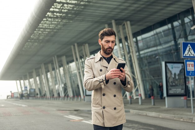 Biznesmen używa smartphone podczas gdy chodzący