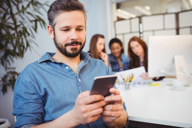 Biznesmen Używa Telefon Komórkowego Przeciw żeńskim Współpracownikom