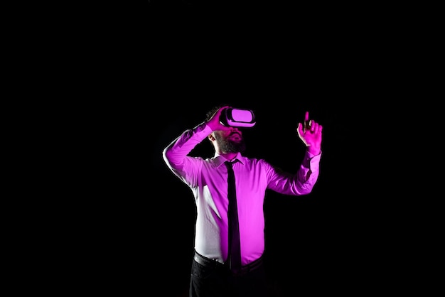 Biznesmen używający gogli wirtualnej rzeczywistości, gestykulujący podczas robienia profesjonalnego światła treningowego