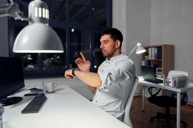 Biznesmen używający inteligentnego zegarka w biurze