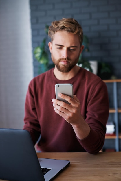Biznesmen używający telefonu komórkowego siedząc w biurze
