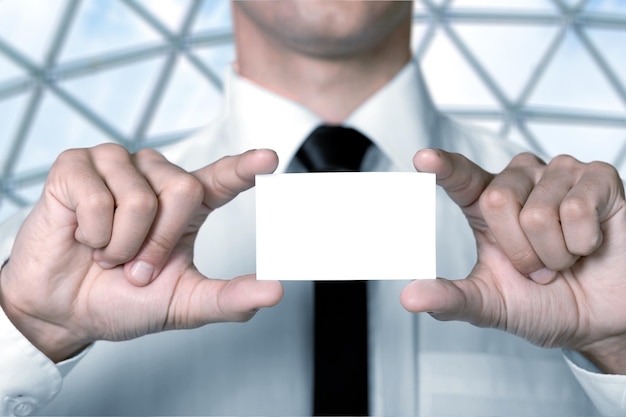 Biznesmen w białej koszuli trzyma pustą kartę w biurze
