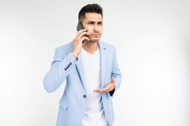 Biznesmen w kurtce omawia ważne sprawy w telefonie na białym tle