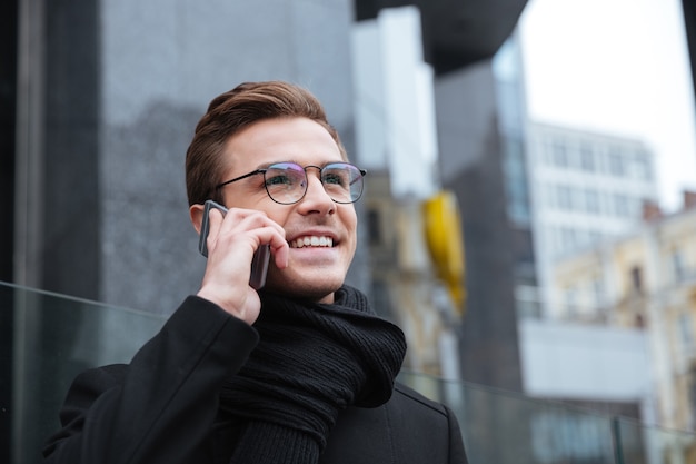 Biznesmen w okularach z telefonem. od dołu