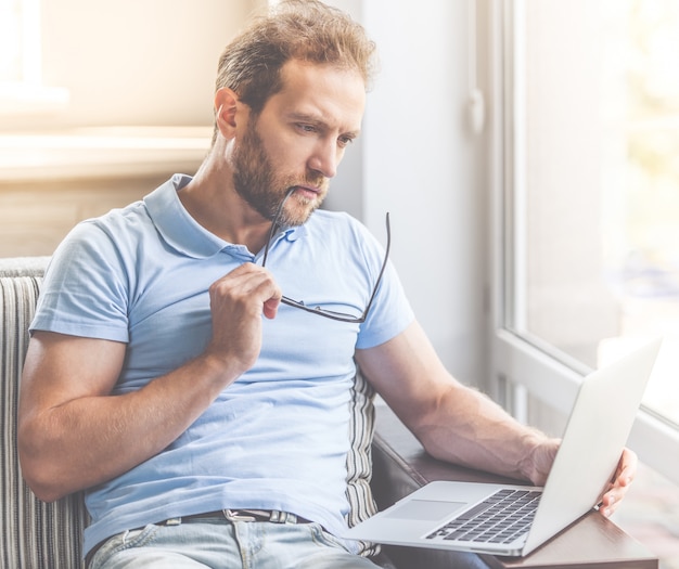 Biznesmen w przypadkowych ubraniach używa laptop