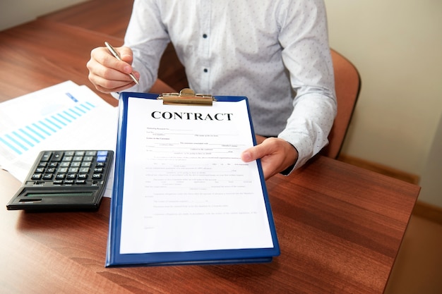 Zdjęcie biznesmen wręcza umowę, trzymając w ręku długopis