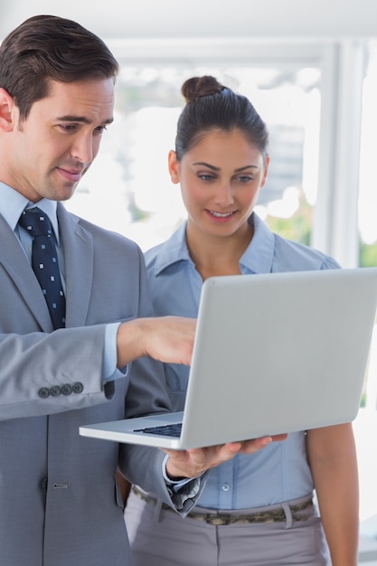 Biznesmen współpracuje patrzeć laptop i ono uśmiecha się