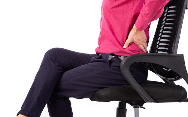 Biznesmen z bólem pleców siedzi na krześle biurowym