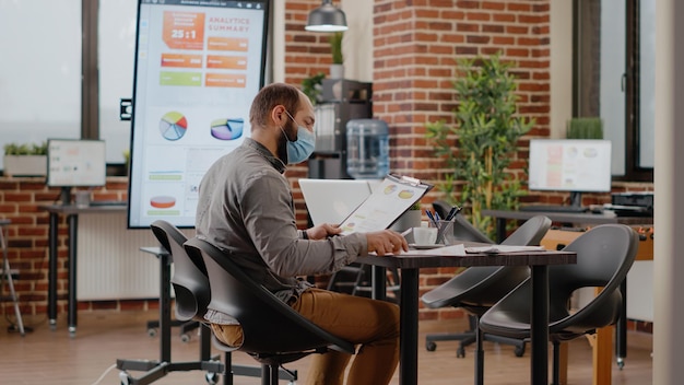 Biznesmen Z Maską Powitania Kolegów W Sali Konferencyjnej, Spotkanie Do Pracy Nad Prezentacją Marketingową I Projektem Podczas Pandemii. Pracownik Współpracujący Z Ludźmi Przy Planowaniu Strategii.