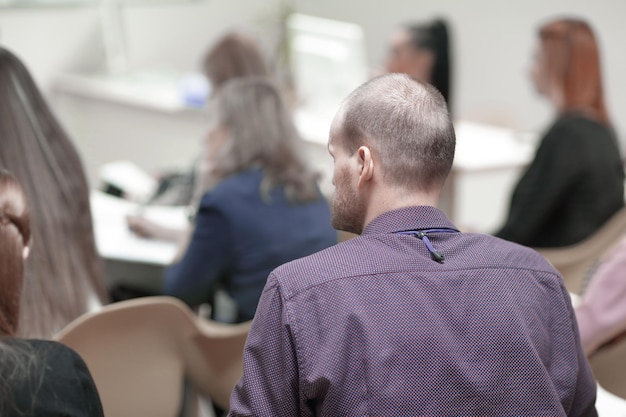 Biznesmen z tyłu siedzący w sali konferencyjnej