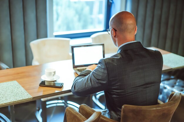 Biznesmen Za Pomocą Cyfrowej Technologii Bezprzewodowej. Widok Z Tyłu Z Sukcesu Kaukaski Mężczyzna