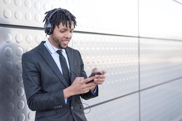 Biznesmen za pomocą smartfona na ulicy słuchając muzyki