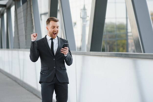 Biznesmen za pomocą smartfona w zadaszonym chodniku