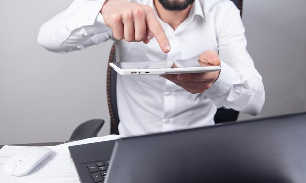 Biznesmen za pomocą swojego cyfrowego tabletu w biurze