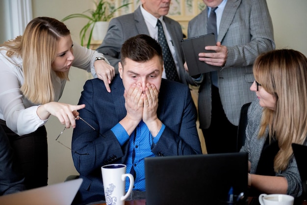 Biznesmen zakrywający twarz rękami stresująca sytuacja w miejscu pracy