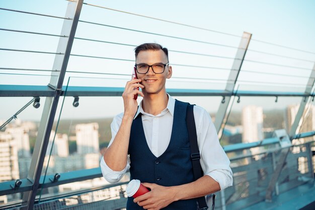 Biznesmen Ze Smartfonem I Kawą Na Wynos Na Stojąco