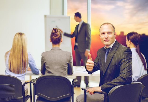 Zdjęcie biznesmeni i koncepcja sukcesu biznesmen z zespołem pokazujący kciuki w biurze nad tłem miasta