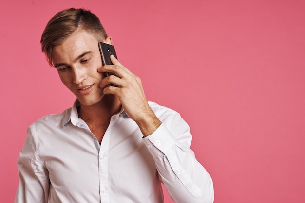 Biznesmeni w białej koszuli rozmawiają przez telefon na białym tle