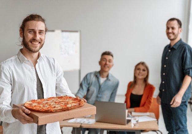 Biznesmeni w przerwie obiadowej jedzą pizzę