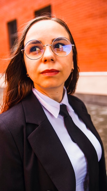 Biznesowa kobieta pozuje Młoda kobieta w okularach garnitur na ulicy miasta