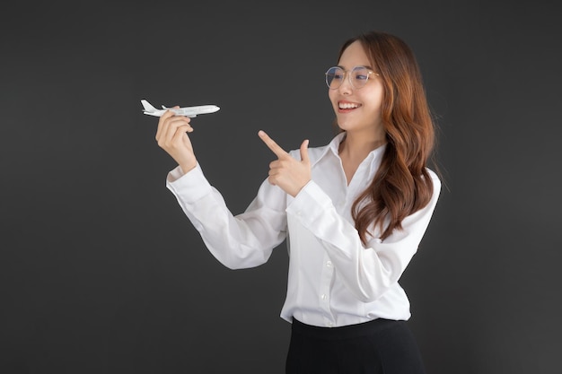 Biznesowa kobieta ubrana w białą koszulę Ręka trzymająca biały samolot-zabawka