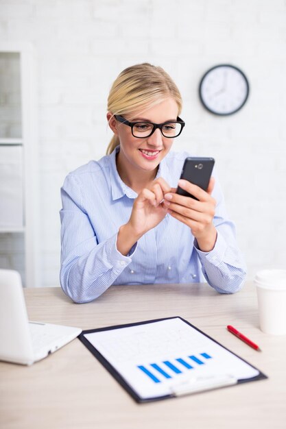 Zdjęcie biznesowa kobieta używa mądrze telefon w biurze