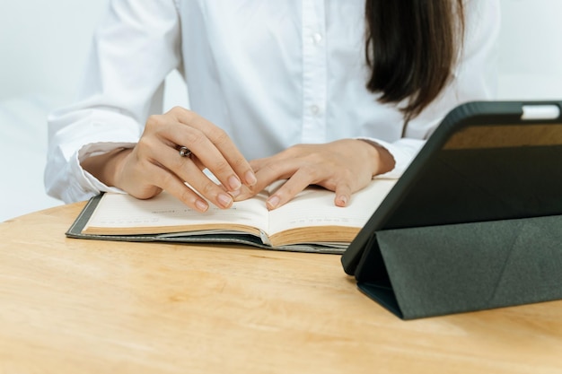Biznesowa kobieta w białej koszuli pracująca i obliczająca finanse z raportem dokumentów i cyfrowym tabletem mobilnym na biurku w domowym biurze cyfrowy marketing online i koncepcja biznesu finansowego