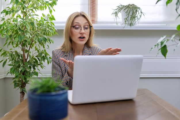 Biznesowa kobieta w średnim wieku pracująca w domu przy użyciu laptopa