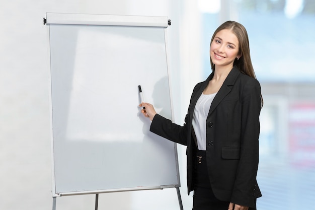 Biznesowa kobieta wyjaśnia przy whiteboard