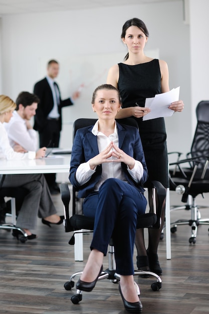 biznesowa kobieta ze swoim personelem, ludzie grupują się w tle w nowoczesnym, jasnym biurze w pomieszczeniu
