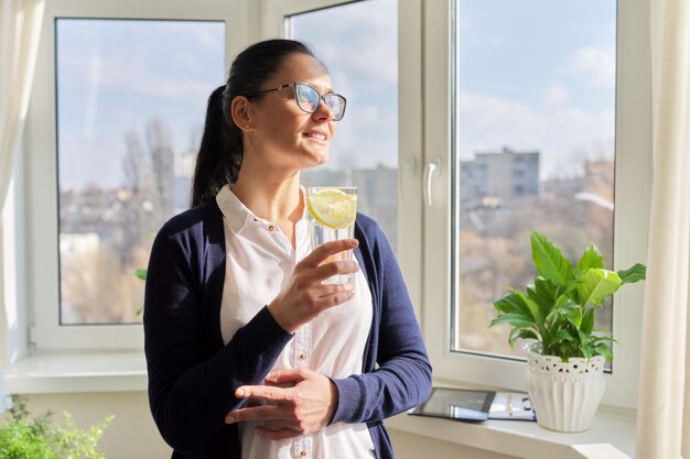 Biznesowa kobieta ze szklanką wody z cytryną