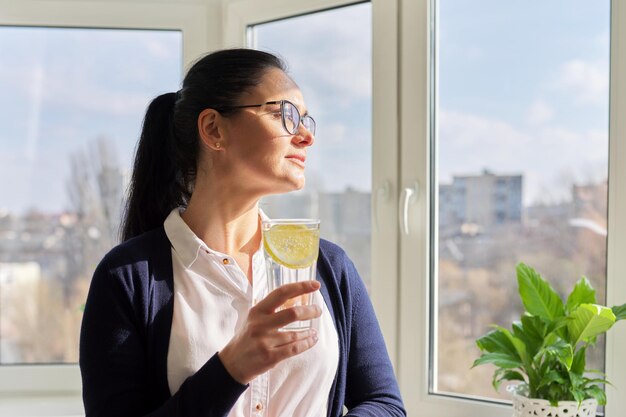 Biznesowa kobieta ze szklanką wody z cytryną