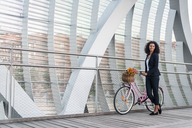 Biznesowa murzynka z rocznika bicyklem w moscie