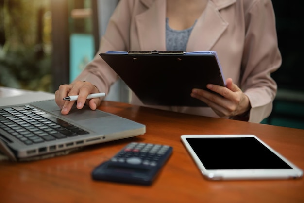 Biznesowe kobiety obliczają i analizują wykres dokumentu finansowego z laptopem przy biurkiem