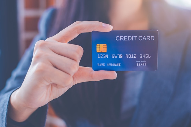 Biznesowe kobiety pokazuje błękitną kredytową kartę