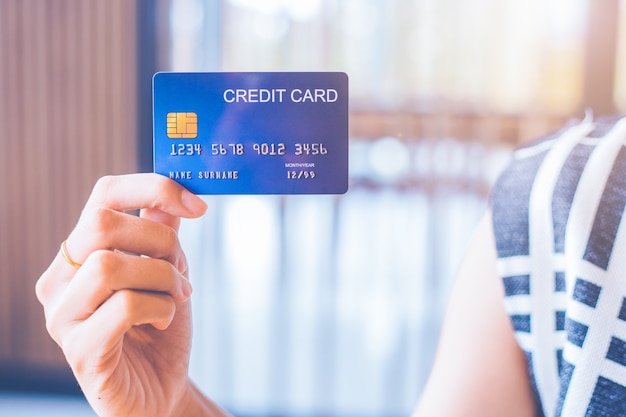 Biznesowej kobiety ręka trzyma błękitną kredytową kartę.