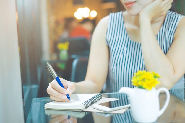 Biznesowej kobiety writing na notebookzith piórem w biurze
