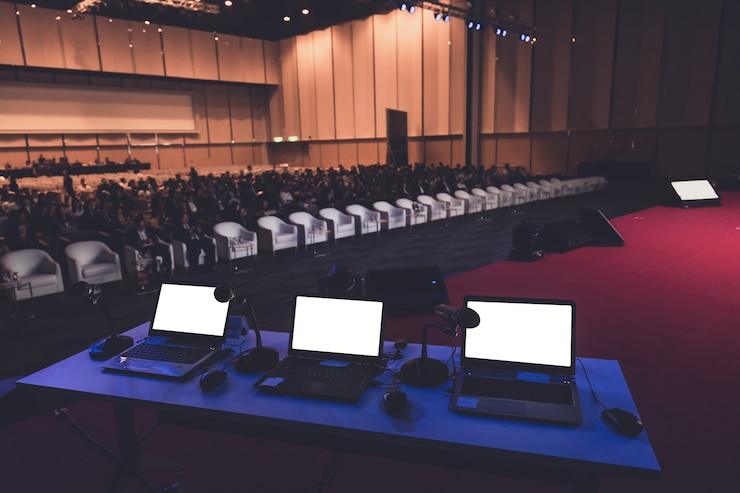Zdjęcie biznesowy laptop i mikrofon przy podium w sala konferencyjnej