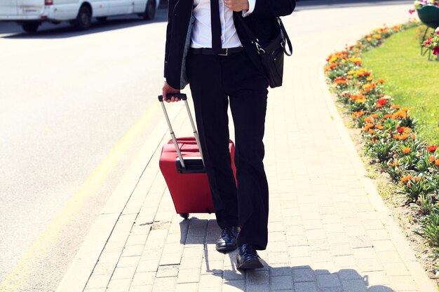 Biznesowy mężczyzna przy lotniskiem z walizką