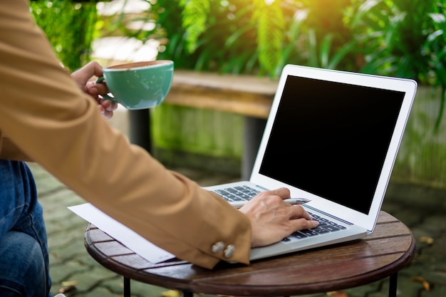 Biznesowy womanworking używać laptop na stole w ogródzie