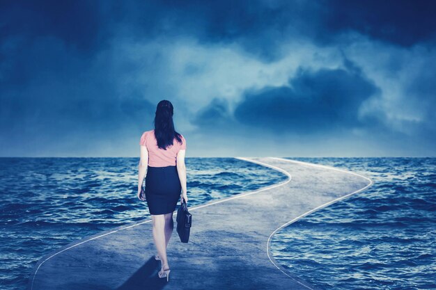 Bizneswoman chodząca po drodze nad morzem