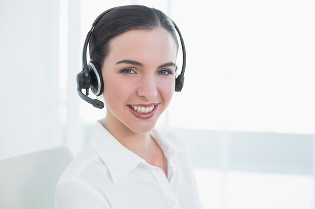 Bizneswoman jest ubranym słuchawki w biurze