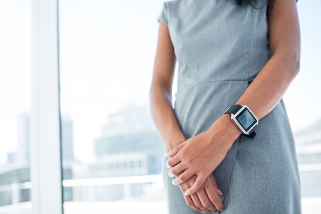 Bizneswoman jest ubranym smartwatch z rękami składać