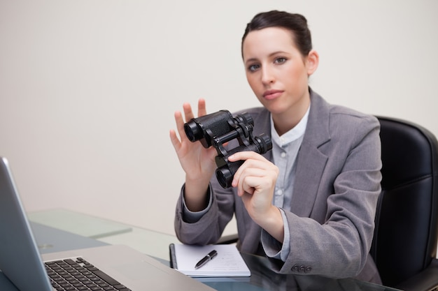 Bizneswoman na jej biurku z lornetkami