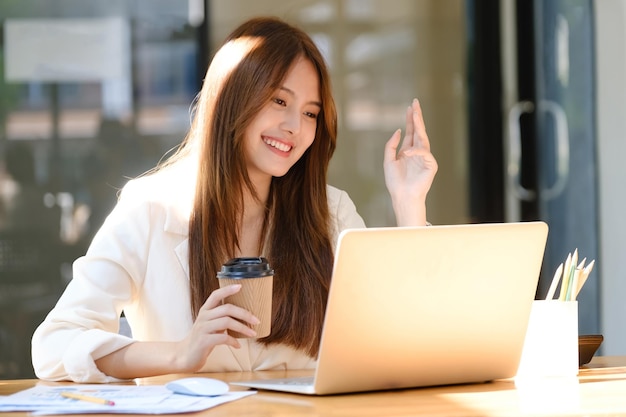 Bizneswoman nawiązuje wideorozmowę z partnerem biznesowym na czacie przed kamerą internetową Wesoła młoda bizneswoman rozmawia wideo na czacie z kolegą xA