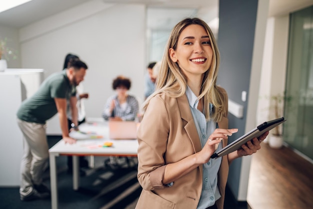 Bizneswoman pozuje i uśmiecha się podczas spotkania w biurze