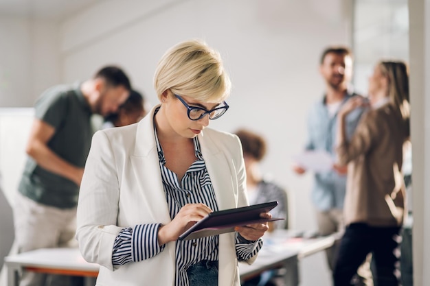 Bizneswoman pozuje i uśmiecha się podczas spotkania w biurze