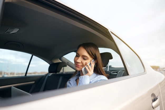Bizneswoman rozmawia przez telefon podczas podróży taksówką