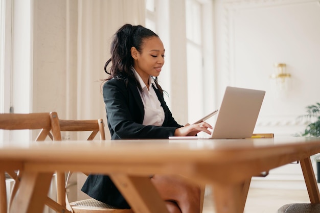 Bizneswoman uśmiecha się, menedżer pracujący na laptopie Prawnik siedzi w nowocześnie wynajętym biurze