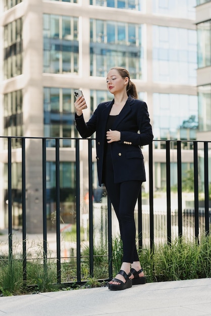 Bizneswoman we współczesnym ogrodzie w skupisku wysokich budynków